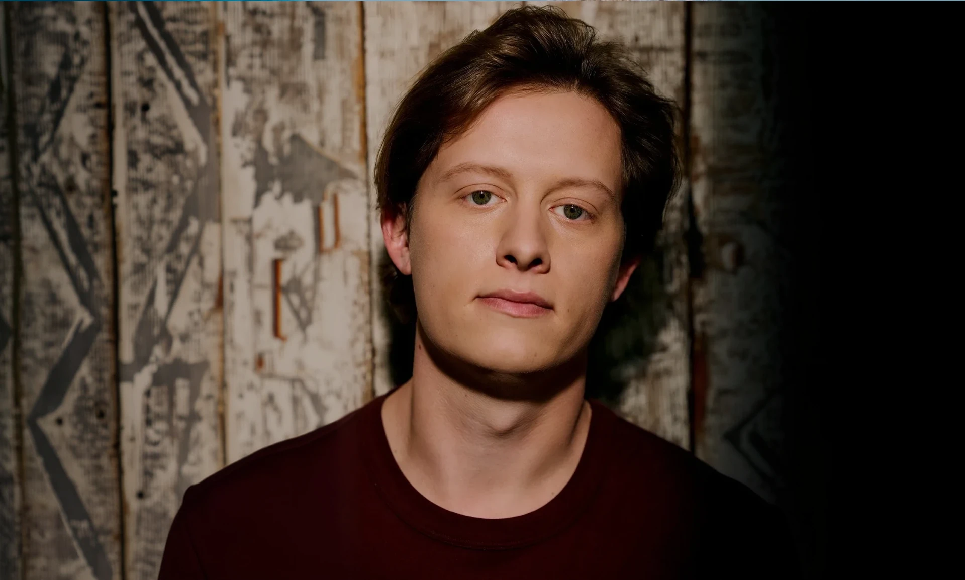 Person standing against a patterned backdrop.