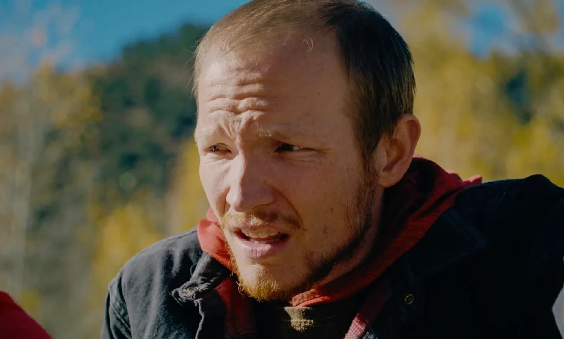 Individual with short hair in outdoor setting