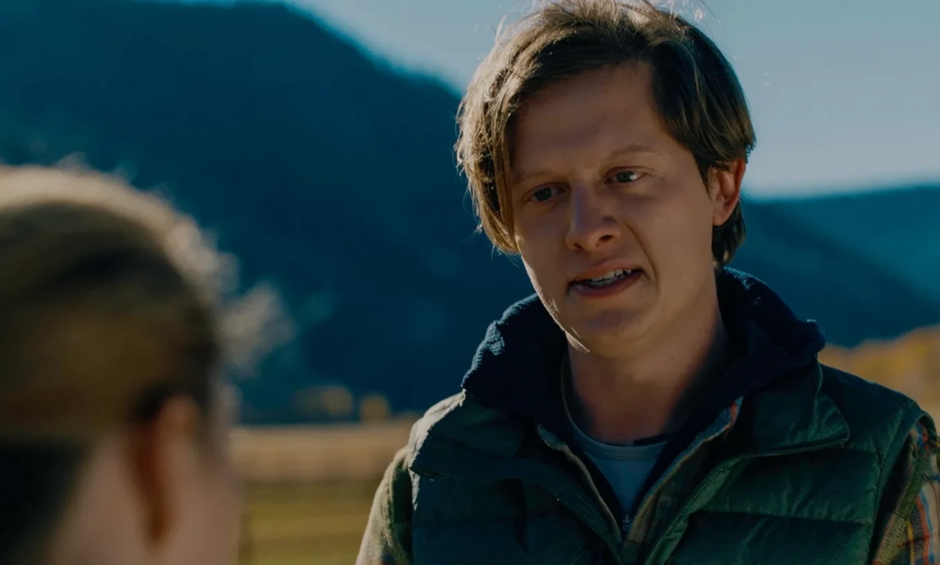 Young man in a green jacket talking