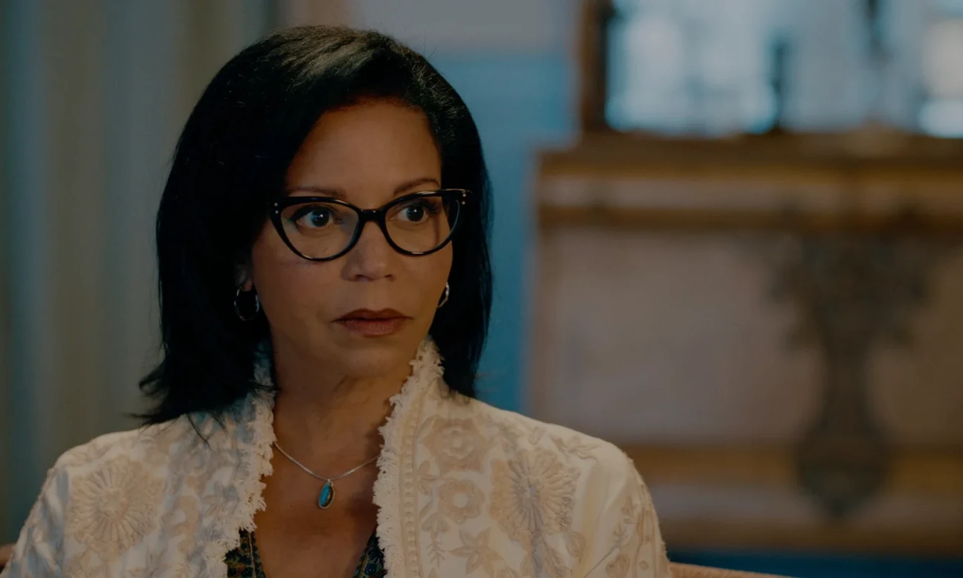 Woman with glasses sitting indoors